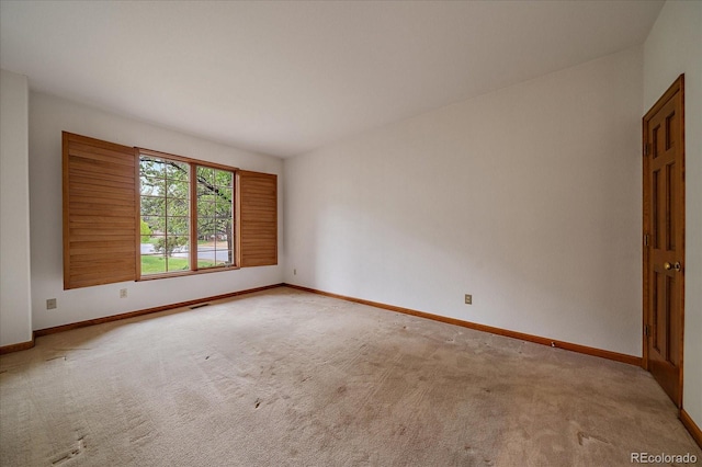 unfurnished room featuring baseboards and carpet