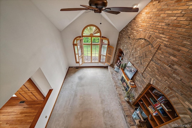 unfurnished living room with high vaulted ceiling and a ceiling fan