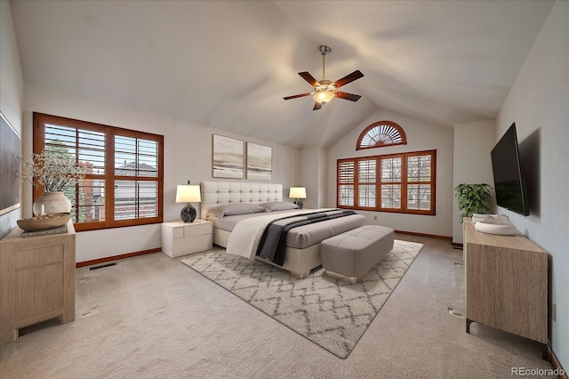 bedroom with light carpet, vaulted ceiling, baseboards, and ceiling fan