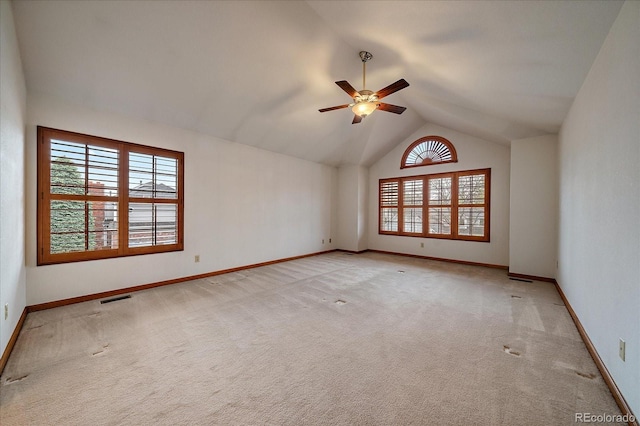 empty room featuring light carpet, lofted ceiling, a ceiling fan, and baseboards