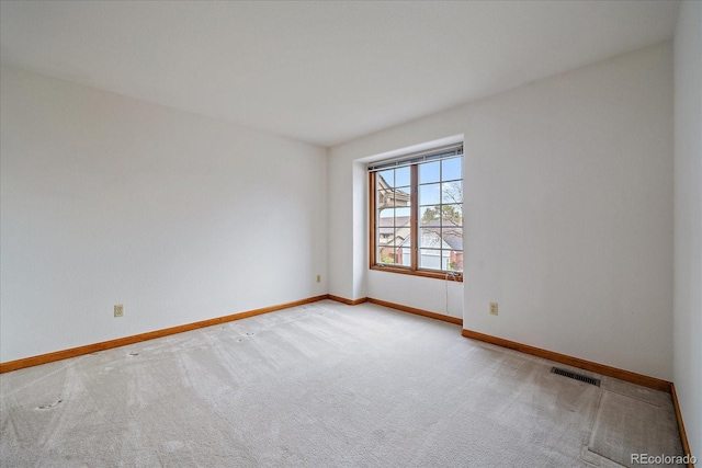 empty room with baseboards and carpet