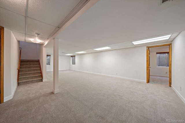 finished below grade area with carpet flooring, stairs, and baseboards