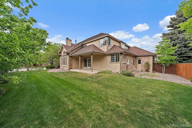 back of property featuring a patio, a chimney, and brick siding