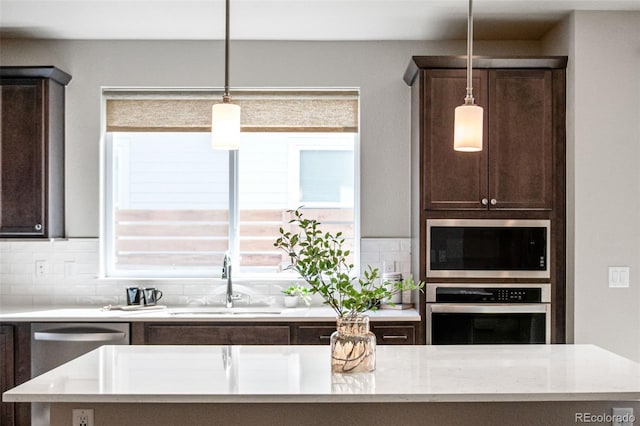 9700 E 63rd Pl, Denver, CO 80238 - kitchen with appliances with stainless steel finishes, a sink, dark brown cabinets, tasteful backsplash, and pendant lighting