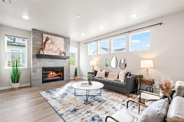 9700 E 63rd Pl, Denver, CO 80238 - living room with a tiled fireplace, wood finished floors, baseboards, and recessed lighting