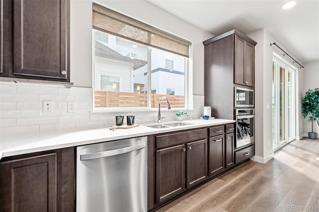9700 E 63rd Pl, Denver, CO 80238 - kitchen with appliances with stainless steel finishes, a sink, light wood-style floors, dark brown cabinets, and recessed lighting