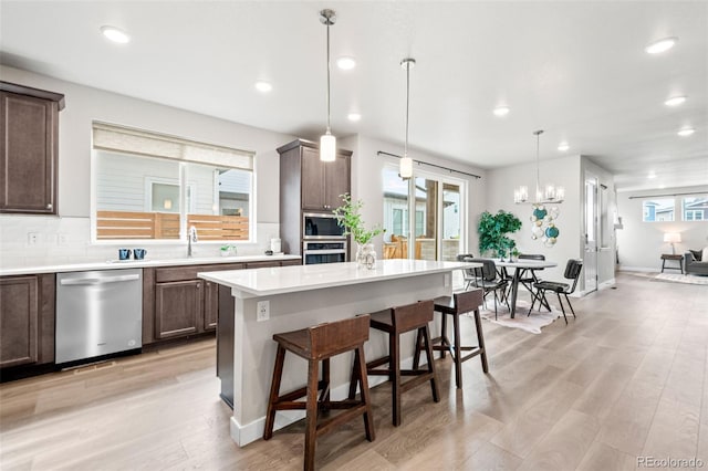 9700 E 63rd Pl, Denver, CO 80238 - kitchen with stainless steel appliances, a kitchen breakfast bar, light countertops, a sink, and recessed lighting