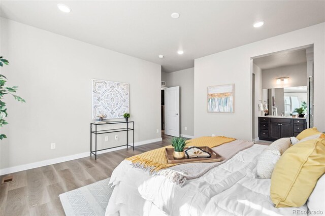 9700 E 63rd Pl, Denver, CO 80238 - bedroom featuring wood finished floors, recessed lighting, baseboards, and ensuite bathroom