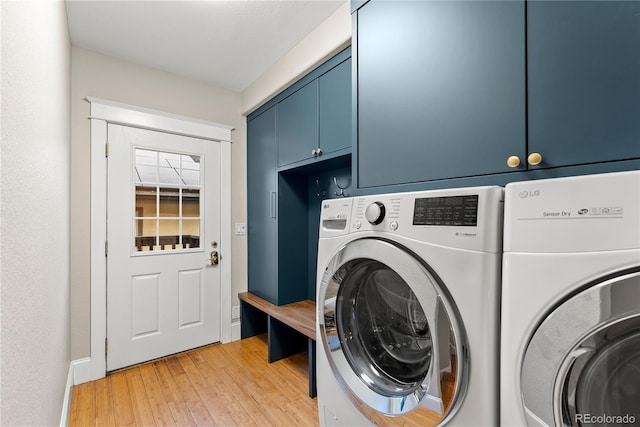 laundry room with cabinet space, separate washer and dryer, and light wood finished floors