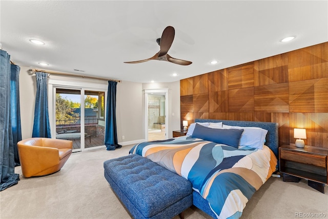 bedroom featuring ensuite bath, ceiling fan, access to outside, carpet flooring, and wood walls