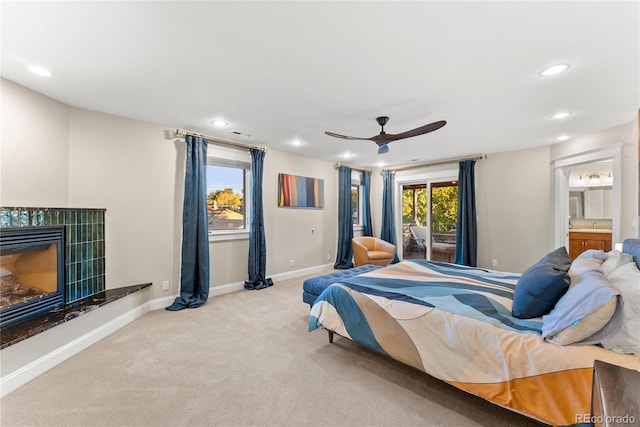 bedroom featuring carpet floors, baseboards, a tiled fireplace, and recessed lighting