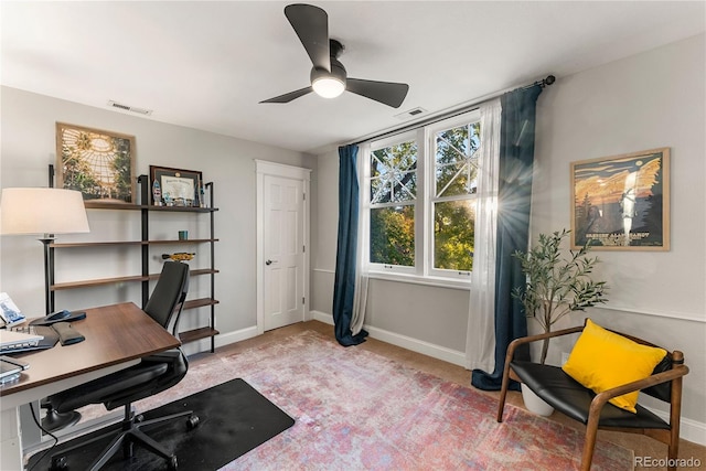 office featuring a ceiling fan, carpet flooring, visible vents, and baseboards