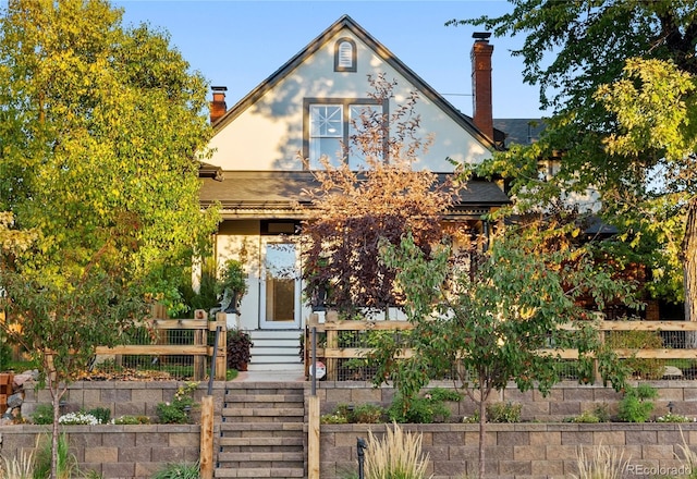 view of front of property featuring fence and a chimney