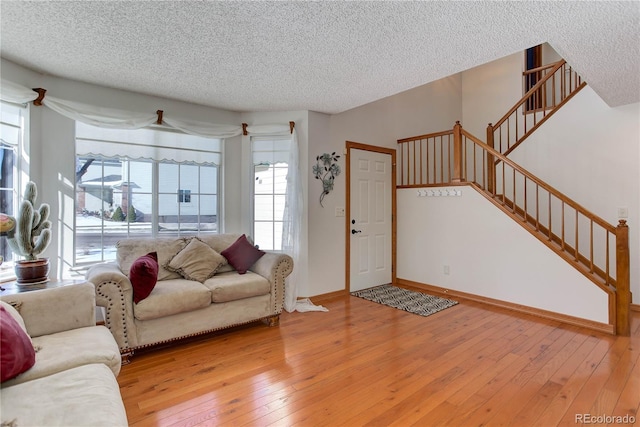 living room with plenty of natural light, a textured ceiling, and light wood-type flooring