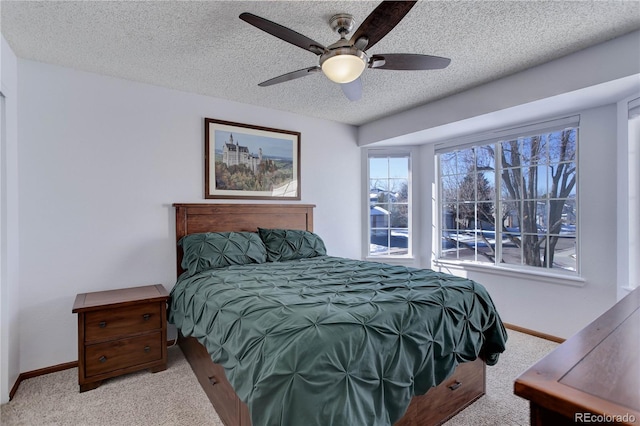 carpeted bedroom with a textured ceiling and ceiling fan