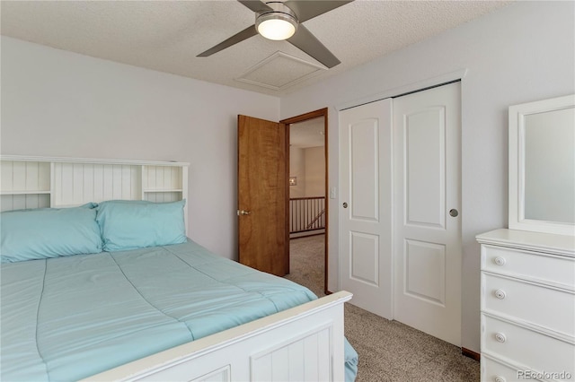 carpeted bedroom with ceiling fan, a closet, and a textured ceiling