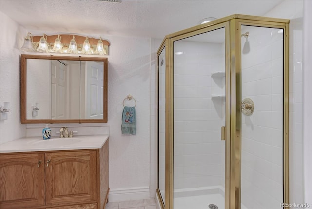 bathroom with vanity, a shower with shower door, and a textured ceiling