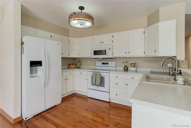 kitchen featuring white appliances, light hardwood / wood-style floors, sink, and white cabinets