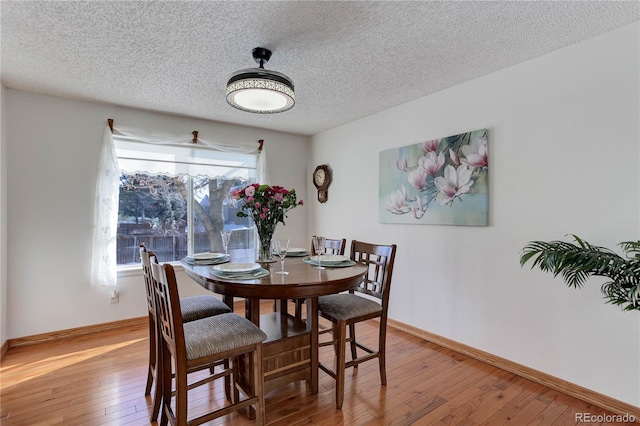 dining area with hardwood / wood-style flooring and a textured ceiling