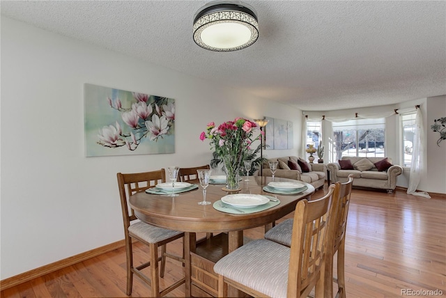 dining room featuring light hardwood / wood-style flooring and a textured ceiling