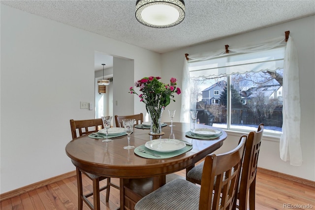 dining room featuring a textured ceiling and light wood-type flooring