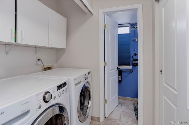 laundry room featuring cabinets, washer and dryer, and light tile patterned flooring