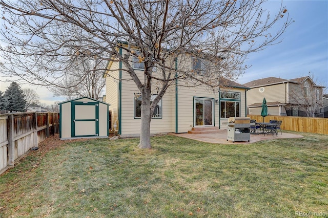 rear view of property featuring a shed, a yard, and a patio