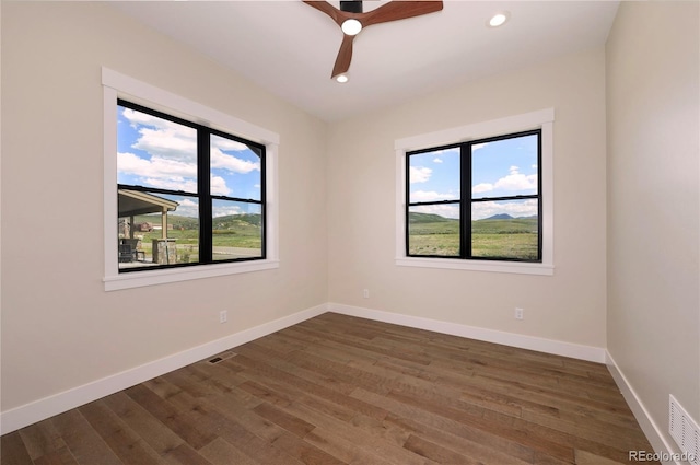 spare room featuring dark hardwood / wood-style flooring and ceiling fan