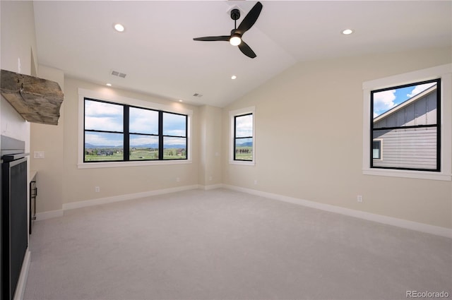 unfurnished living room featuring ceiling fan, light colored carpet, and lofted ceiling