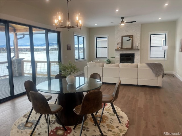 dining space featuring a large fireplace, hardwood / wood-style floors, and a chandelier