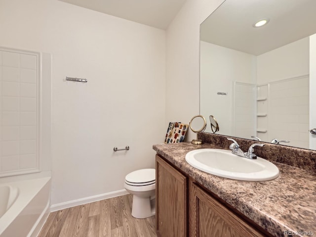 full bathroom featuring shower / washtub combination, toilet, vanity, wood finished floors, and baseboards