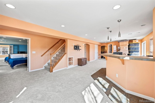 1929 Baguette Dr, Castle Rock, CO 80108 - kitchen with open floor plan, a kitchen bar, dark carpet, recessed lighting, and arched walkways