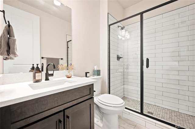 bathroom featuring toilet, marble finish floor, a shower stall, and vanity