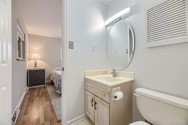 bathroom with wood-type flooring, vanity, and toilet