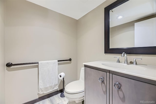 bathroom with hardwood / wood-style floors, vanity, and toilet