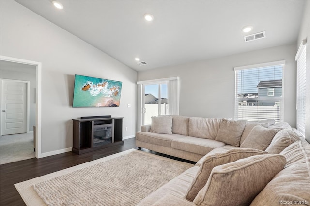 living room featuring dark hardwood / wood-style floors, a fireplace, and high vaulted ceiling