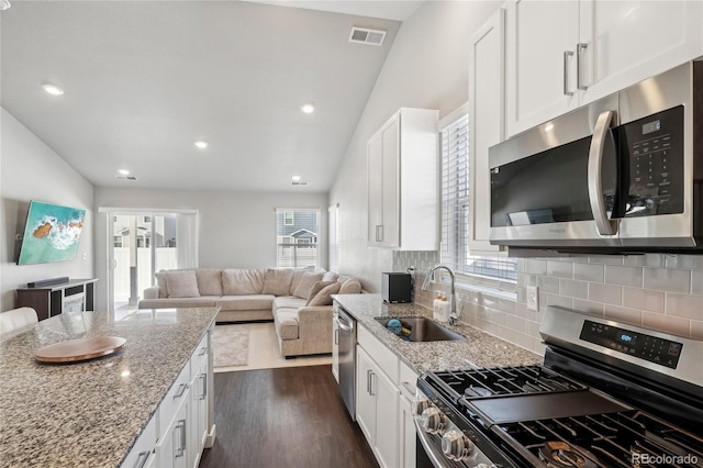 kitchen featuring dark hardwood / wood-style floors, sink, white cabinets, stainless steel appliances, and light stone countertops