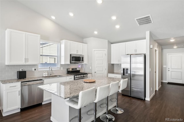 kitchen featuring white cabinetry, sink, stainless steel appliances, and a center island