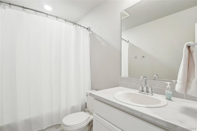 bathroom featuring vanity, backsplash, and toilet