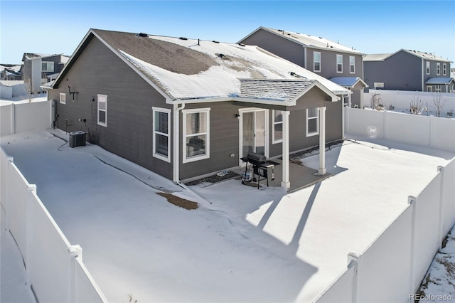 snow covered back of property featuring cooling unit