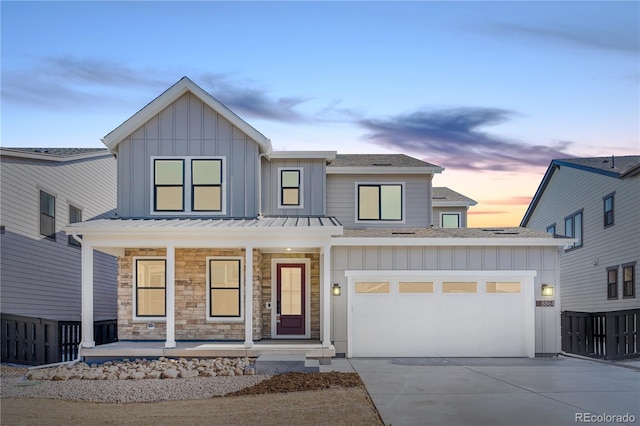 view of front of home with driveway, covered porch, and board and batten siding