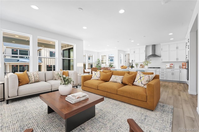 living area featuring light wood-type flooring and recessed lighting