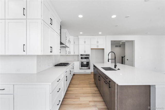 kitchen with a spacious island, a sink, and white cabinets