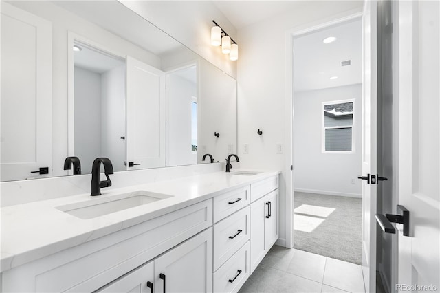 bathroom featuring tile patterned floors, visible vents, a sink, and double vanity