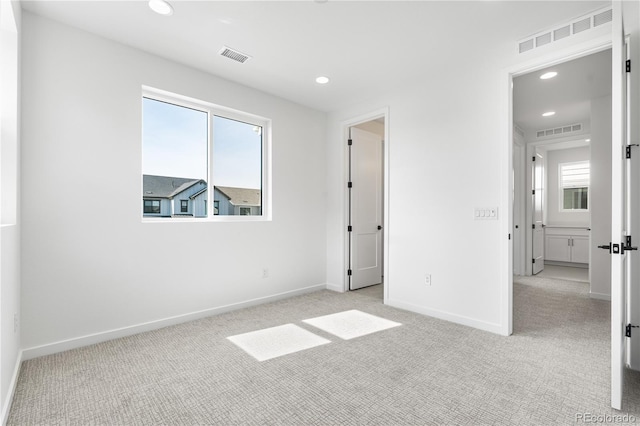 unfurnished bedroom featuring light carpet, visible vents, and baseboards