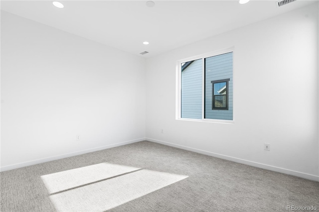 unfurnished room featuring baseboards, carpet flooring, visible vents, and recessed lighting