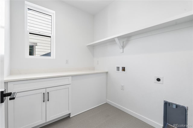 clothes washing area featuring hookup for a washing machine, light colored carpet, cabinet space, electric dryer hookup, and baseboards