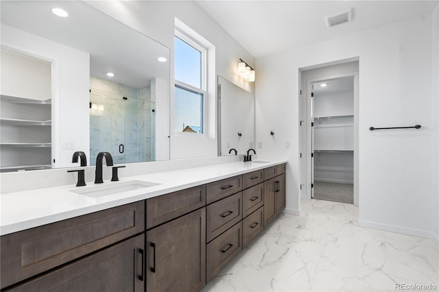 full bathroom with a marble finish shower, visible vents, a walk in closet, and a sink