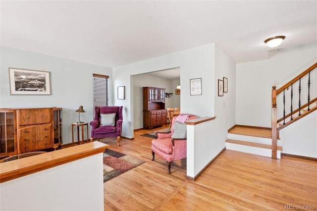 3151 E 134th Cir, Thornton, CO 80241 - living room featuring light wood-type flooring, stairway, and baseboards