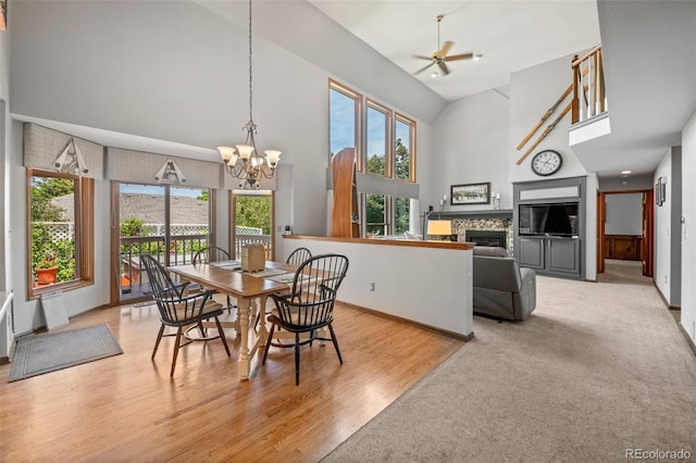 4161 W Lake Cir N, Littleton, CO 80123 - dining space featuring a high ceiling, a chandelier, healthy amount of natural light, ceiling fan, and a fireplace